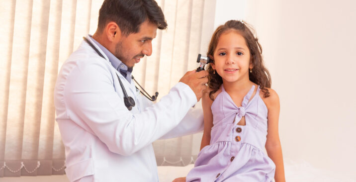 Doctor examines ear with otoscope in a pediatrician room. Medical equipment